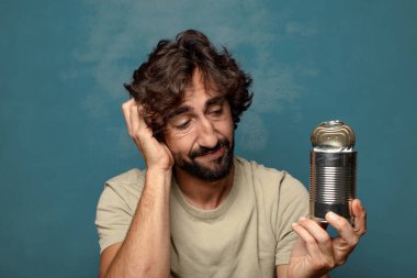 Genç, sakallı, çelik tenekeli adam.