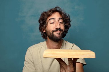 Boş tahta kesim masası olan genç, sakallı bir adam.