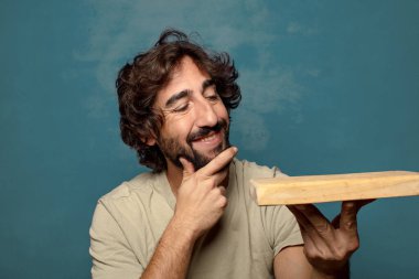 Boş tahta kesim masası olan genç, sakallı bir adam.