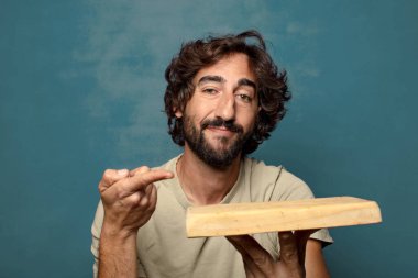 Boş tahta kesim masası olan genç, sakallı bir adam.