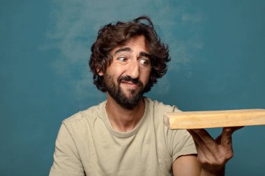 Boş tahta kesim masası olan genç, sakallı bir adam.