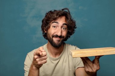 Boş tahta kesim masası olan genç, sakallı bir adam.