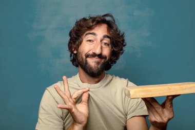 Boş tahta kesim masası olan genç, sakallı bir adam.