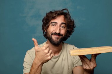 Boş tahta kesim masası olan genç, sakallı bir adam.