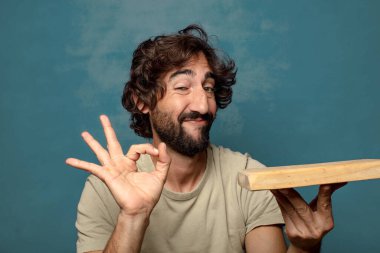 Boş tahta kesim masası olan genç, sakallı bir adam.