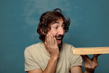 Boş tahta kesim masası olan genç, sakallı bir adam.