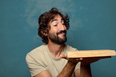 Boş tahta kesim masası olan genç, sakallı bir adam.