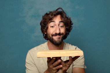 Boş tahta kesim masası olan genç, sakallı bir adam.