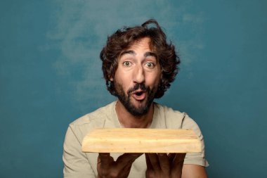 Boş tahta kesim masası olan genç, sakallı bir adam.