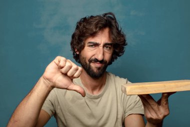 Boş tahta kesim masası olan genç, sakallı bir adam.