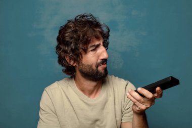 Uzaktan kumandalı sakallı genç bir adam.