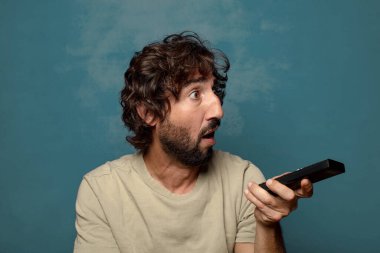 Uzaktan kumandalı sakallı genç bir adam.