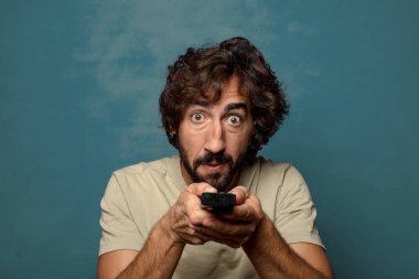 Uzaktan kumandalı sakallı genç bir adam.