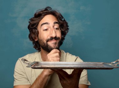 Gümüş tepsisi olan genç, sakallı bir adam.