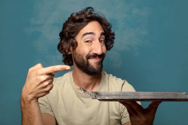 Gümüş tepsisi olan genç, sakallı bir adam.