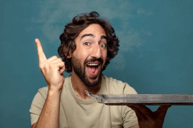 Gümüş tepsisi olan genç, sakallı bir adam.