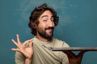 Gümüş tepsisi olan genç, sakallı bir adam.