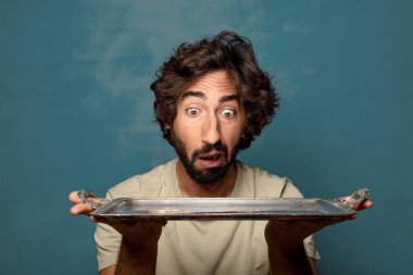 Gümüş tepsisi olan genç, sakallı bir adam.