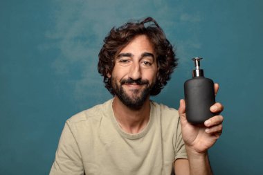 Sabun makinesi olan genç, sakallı bir adam.