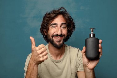 Sabun makinesi olan genç, sakallı bir adam.