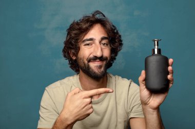 Sabun makinesi olan genç, sakallı bir adam.