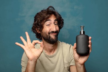 Sabun makinesi olan genç, sakallı bir adam.