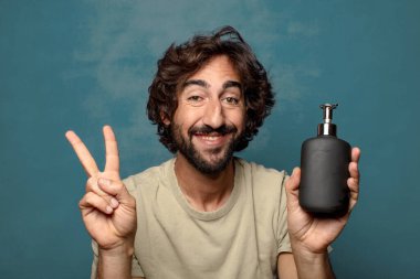 Sabun makinesi olan genç, sakallı bir adam.