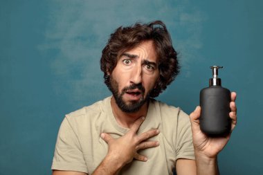 Sabun makinesi olan genç, sakallı bir adam.