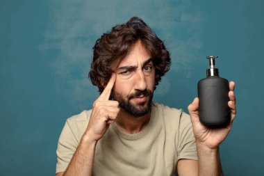 Sabun makinesi olan genç, sakallı bir adam.