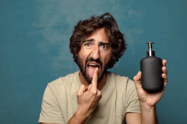 Sabun makinesi olan genç, sakallı bir adam.