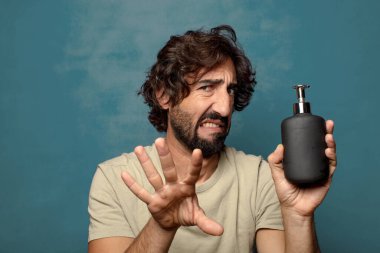 Sabun makinesi olan genç, sakallı bir adam.