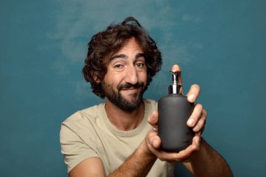 Sabun makinesi olan genç, sakallı bir adam.