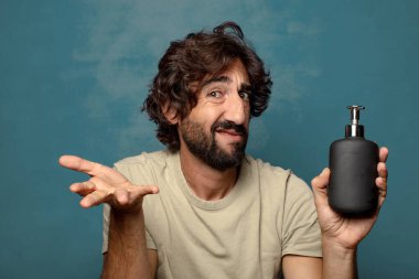 Sabun makinesi olan genç, sakallı bir adam.