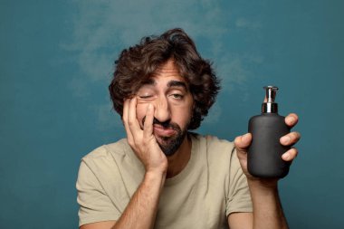 Sabun makinesi olan genç, sakallı bir adam.