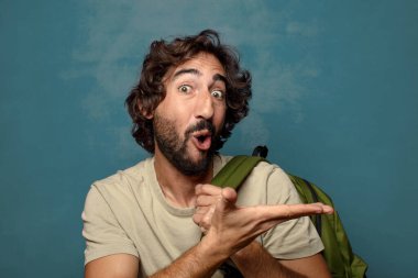 Çantası olan genç, sakallı bir adam.