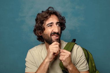 Çantası olan genç, sakallı bir adam.