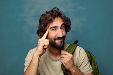 Çantası olan genç, sakallı bir adam.