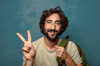 Çantası olan genç, sakallı bir adam.