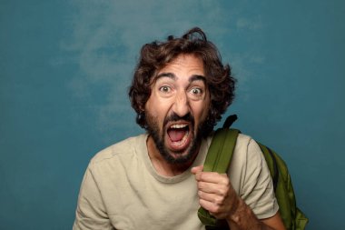 Çantası olan genç, sakallı bir adam.