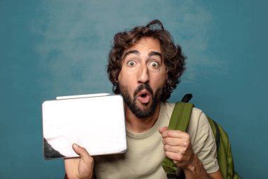 Çantası olan genç, sakallı bir adam.