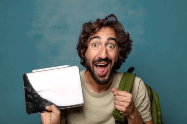 Çantası olan genç, sakallı bir adam.