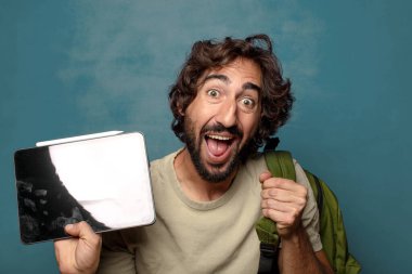 Çantası olan genç, sakallı bir adam.