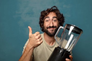 Genç, sakallı, blender makineli bir adam.