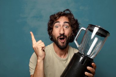 Genç, sakallı, blender makineli bir adam.