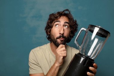Genç, sakallı, blender makineli bir adam.