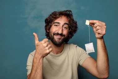 Genç, sakallı, çay içen bir adam.