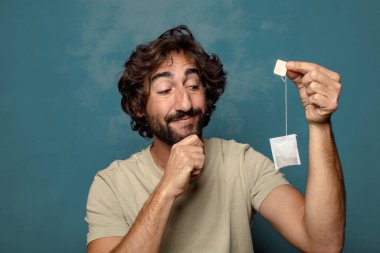 Genç, sakallı, çay içen bir adam.