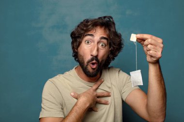 Genç, sakallı, çay içen bir adam.