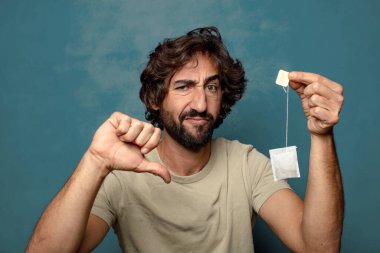 Genç, sakallı, çay içen bir adam.