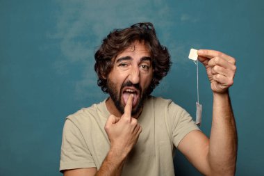 Genç, sakallı, çay içen bir adam.